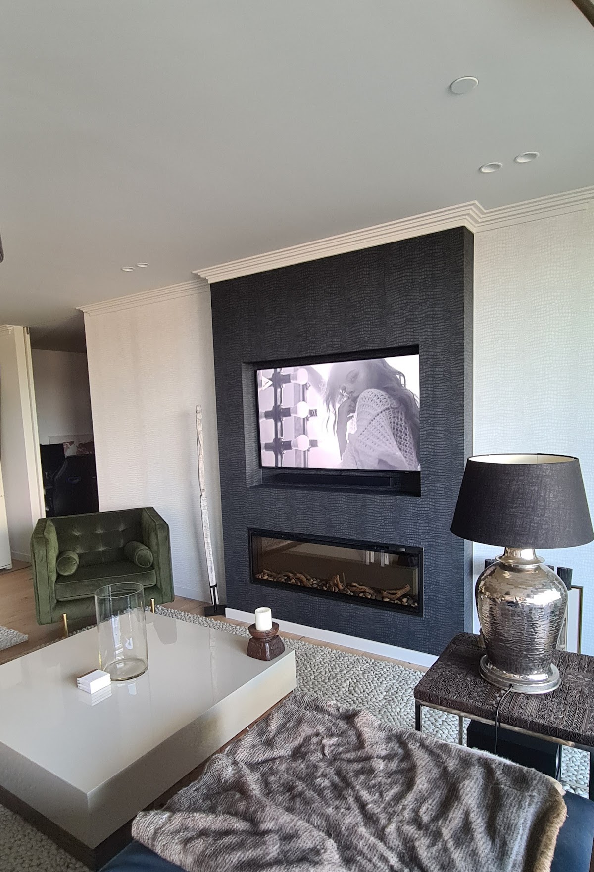 An interior feature wall with dark textured wallpaper and crisp white trim
