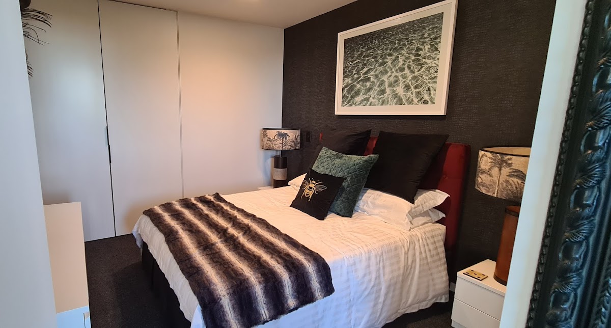 Bedroom with a feature wall and crisp white joinery
